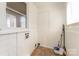 Functional laundry room with white walls, a window, and a utility sink at 502 Crawford St, Shelby, NC 28150