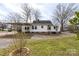 Charming backyard with white siding, a covered carport, and mature shade trees at 609 Eddleman Rd, Kannapolis, NC 28083
