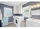 This renovated bathroom features a washer and dryer, white cabinets, and updated fixtures at 609 Eddleman Rd, Kannapolis, NC 28083