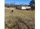 Back view of the home showing a dark deck with stairs into the yard at 8183 Hallman Mill Rd, Vale, NC 28168