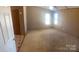 Spacious main bedroom with neutral carpet, a ceiling fan, and two large windows at 8183 Hallman Mill Rd, Vale, NC 28168