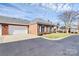 Charming brick home featuring a well-manicured lawn, landscaping, and an attached garage under a partly cloudy sky at 8462 Highland Glen Dr, Charlotte, NC 28269