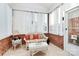 Cozy sunroom with brick walls, a glass-top table, and a wicker sofa for relaxation at 8462 Highland Glen Dr, Charlotte, NC 28269