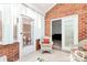 Inviting sunroom featuring brick accent wall, neutral tile flooring, and comfortable wicker seating at 8462 Highland Glen Dr, Charlotte, NC 28269