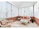 Light-filled sunroom boasts brick walls, vertical blinds, and comfortable wicker furniture for relaxation at 8462 Highland Glen Dr, Charlotte, NC 28269