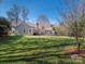 Back exterior of home with deck and large grassy yard surrounded by trees at 9307 Harlow Creek Rd, Huntersville, NC 28078