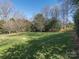 Large grassy back yard surrounded by mature trees at 9307 Harlow Creek Rd, Huntersville, NC 28078