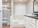 Cozy bathroom features a shower-tub combo with tiled walls and a vanity with modern fixtures at 9307 Harlow Creek Rd, Huntersville, NC 28078