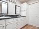 Bathroom featuring dual sinks with black countertops, white cabinets, and a large linen closet at 9307 Harlow Creek Rd, Huntersville, NC 28078