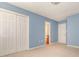Carpeted bedroom painted blue featuring two closets and a door leading to the bathroom at 9307 Harlow Creek Rd, Huntersville, NC 28078
