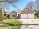 Charming home featuring a two-car garage and beautiful landscaping, set against a clear blue sky at 9307 Harlow Creek Rd, Huntersville, NC 28078
