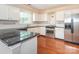 Stylish kitchen featuring stainless steel appliances, granite countertops, and white cabinetry at 9307 Harlow Creek Rd, Huntersville, NC 28078