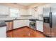 Modern kitchen featuring stainless steel appliances, granite countertops, and white cabinetry at 9307 Harlow Creek Rd, Huntersville, NC 28078
