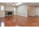 Living room with stone fireplace, hardwood floors, skylight, and neutral walls at 9307 Harlow Creek Rd, Huntersville, NC 28078