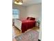 Cozy bedroom with hardwood floors, two windows, and a plush red bedspread at 1003 Woodland Dr, Gastonia, NC 28054