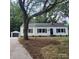 Charming single-story home with black shutters and a detached garage, nestled under mature trees at 1003 Woodland Dr, Gastonia, NC 28054