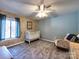 Light filled bedroom featuring a ceiling fan, neutral walls, plush carpet, a rocking chair and crib at 1022 Mallard Head Ln, Mooresville, NC 28117