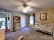 Light filled bedroom featuring a ceiling fan, neutral walls, plush carpet, closet and crib at 1022 Mallard Head Ln, Mooresville, NC 28117