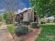 Condo exterior featuring a stone facade, wood siding, and landscaped grounds with mature trees at 1022 Mallard Head Ln, Mooresville, NC 28117
