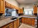 The kitchen has wooden cabinets, granite countertops, stainless appliances, and view of living area at 1022 Mallard Head Ln, Mooresville, NC 28117