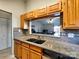 Kitchen featuring wood cabinets and a granite counter, offering a view to the living room at 1022 Mallard Head Ln, Mooresville, NC 28117