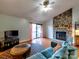 A living room featuring a stone fireplace, hardwood floors, and access to a balcony at 1022 Mallard Head Ln, Mooresville, NC 28117