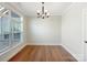 Bright dining room featuring hardwood floors, a window, and modern chandelier, perfect for gatherings at 1063 Millview Ln, Matthews, NC 28104