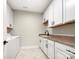 Bright laundry room featuring ample white cabinetry, granite countertop, and stainless washer and dryer at 1063 Millview Ln, Matthews, NC 28104