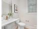 Clean and modern half bathroom featuring a pedestal sink, elegant fixtures, and natural lighting at 109 Seldon Dr, Charlotte, NC 28216