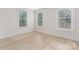 Bright bedroom featuring hardwood floors and natural light from the three large windows at 109 Seldon Dr, Charlotte, NC 28216