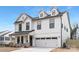 Charming two-story home featuring white siding, black window frames, and a convenient two-car garage at 109 Seldon Dr, Charlotte, NC 28216