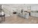 Open kitchen and dining area with light wood floors, white cabinetry, and a large center island with bar stools at 109 Seldon Dr, Charlotte, NC 28216