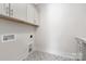 Laundry room featuring stylish tile flooring and storage cabinets at 109 Seldon Dr, Charlotte, NC 28216