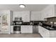 This kitchen features white cabinets, black countertops, stainless steel appliances and tile backsplash at 11 Woodvine Ln, Clover, SC 29710