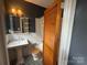 Charming bathroom featuring black and white tile floor, pedestal sink, and wood accents at 1121 Myrtle Ave # 17, Charlotte, NC 28203