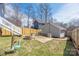 Large backyard featuring a firepit, seating, garden, and a detached garage at 12304 Huntersville Concord Rd, Huntersville, NC 28078