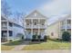 Charming two-story home features a double porch, a blue front door, and well-maintained landscaping at 12304 Huntersville Concord Rd, Huntersville, NC 28078
