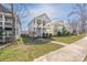Street view of a two-story home with double porches, a grassy front yard, and sidewalk access at 12304 Huntersville Concord Rd, Huntersville, NC 28078
