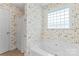 A bright bathroom features a white jacuzzi style tub with a shower and glass block window at 1278 Gracebrook Dr, Salisbury, NC 28147