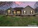 Charming one-story home featuring manicured lawn, neutral siding, and a welcoming front porch at twilight at 1278 Gracebrook Dr, Salisbury, NC 28147