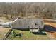Aerial view of the home with a deck, playground, and storage containers in a wooded surrounding at 1298 Hines Rd, Clover, SC 29710