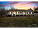 Charming home with inviting front porch, well-manicured lawn, and mature trees against a sunset backdrop at 1298 Hines Rd, Clover, SC 29710