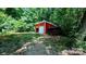 Red outbuilding featuring a garage door and a fenced storage area at 1298 Hines Rd, Clover, SC 29710