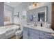 Bathroom features a soaking tub, a large mirror, and a vanity with white countertops and blue cabinets at 13913 Queens Harbor Rd, Charlotte, NC 28278