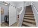 Hallway includes modern barn door leading to laundry and carpeted stairs to the second floor at 13913 Queens Harbor Rd, Charlotte, NC 28278