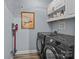 Functional laundry room with modern black washer and dryer, complemented by white shelving at 13913 Queens Harbor Rd, Charlotte, NC 28278