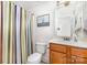 Bright bathroom with a single sink vanity, toilet, and a shower with colorful curtain at 14014 Acorn Creek Ln, Charlotte, NC 28269
