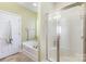 Bright bathroom features large tub, glass-enclosed shower, and modern fixtures at 14014 Acorn Creek Ln, Charlotte, NC 28269