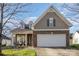 Charming home featuring a brick facade, two-car garage, well-manicured lawn, and covered front porch at 14014 Acorn Creek Ln, Charlotte, NC 28269