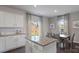 Kitchen boasts white cabinets, granite countertops, stainless appliances and dining area with large windows at 1420 6Th Ne St, Hickory, NC 28601